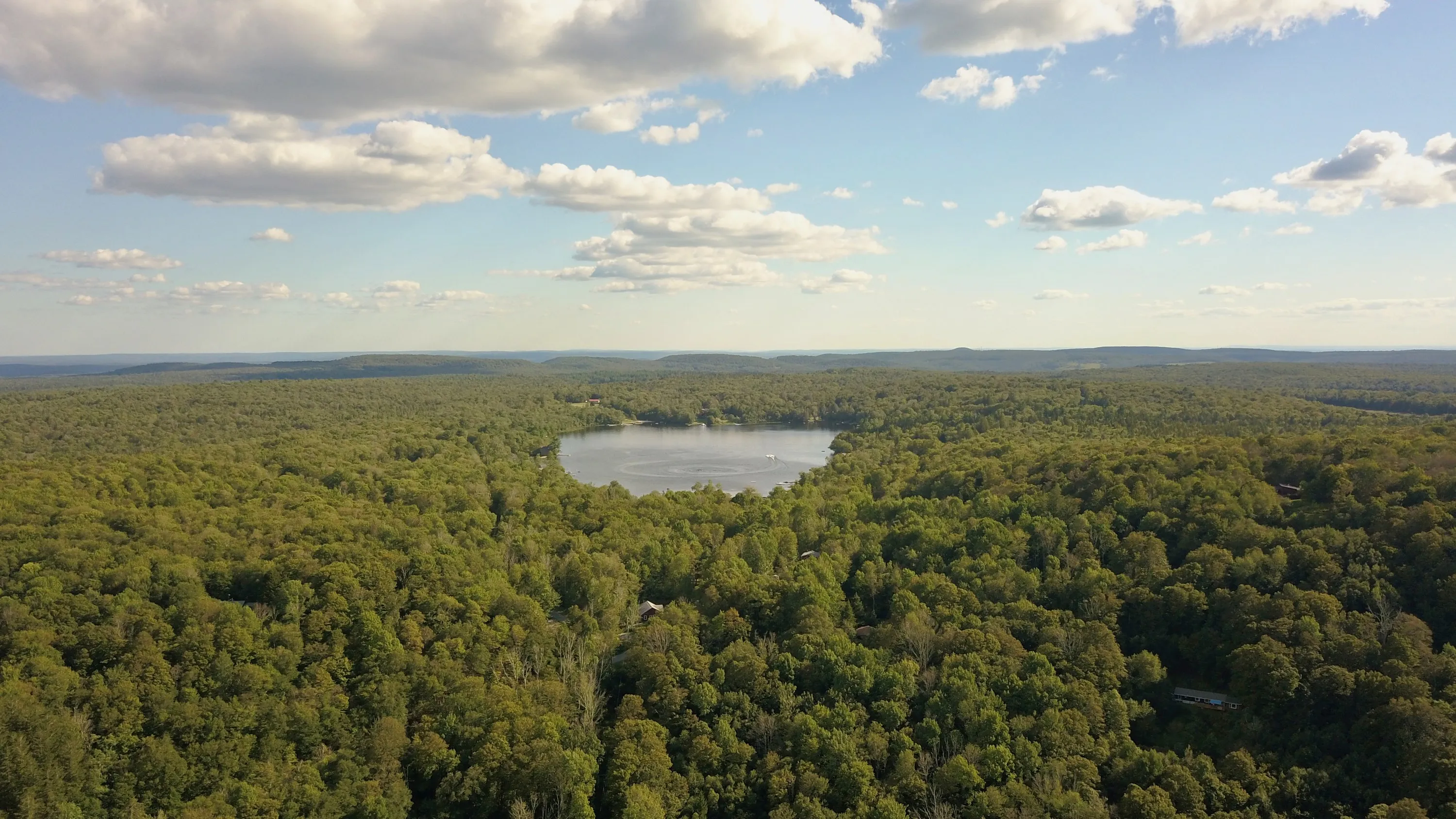 Hunter Lake set in the forest below Evergreen Overlook, with the Catskill ridgelines beyond